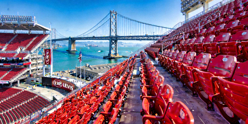旧金山李维斯体育场现代化的红色座椅和海湾大桥背景