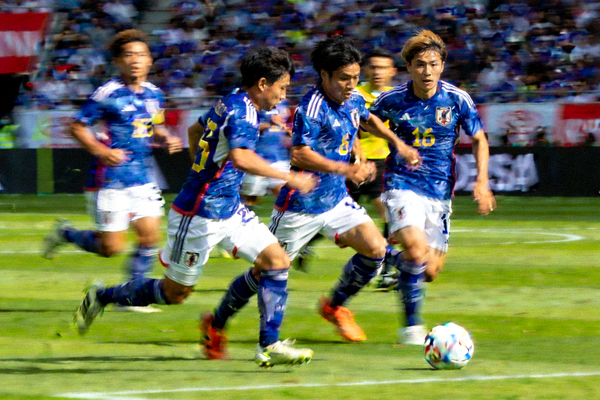 日本队球员通过不懈的跑动和团队配合在局部形成以多打少局面的比赛场景