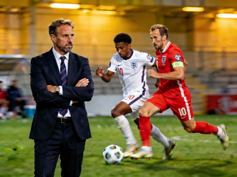 英格兰队贝林厄姆与凯恩在进攻中配合，索斯盖特在场边观赛